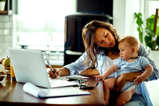 Maman devant un pc s'occupant de son bébé